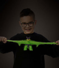 Load image into Gallery viewer, Goo Jit Zu Glow Shifters Scorpius toy being stretched by a child, glowing bright green in the dark.